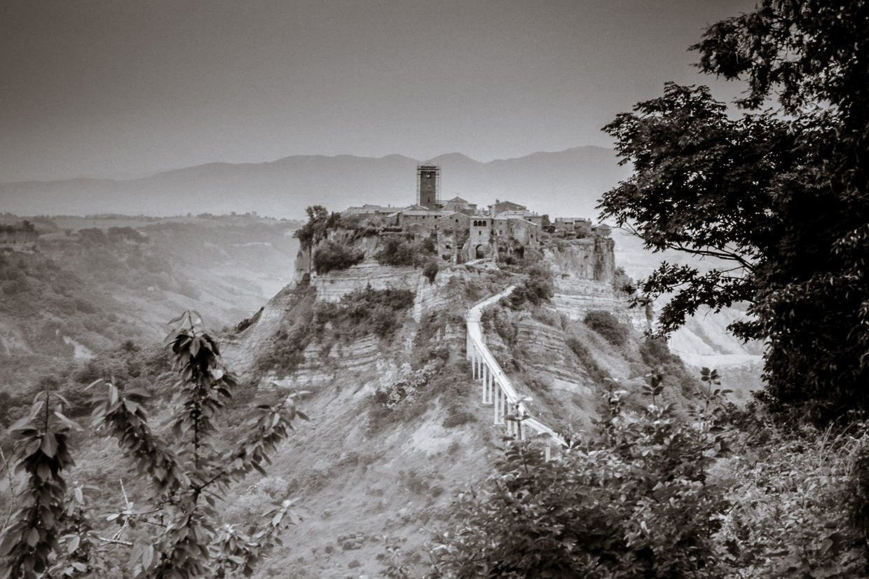 Un'incantevole veduta di Civita di Bagnoregio, il borgo che sembra fluttuare nel vuoto grazie al fenomeno della foschia, un'esperienza magica sospesa tra cielo e terra.